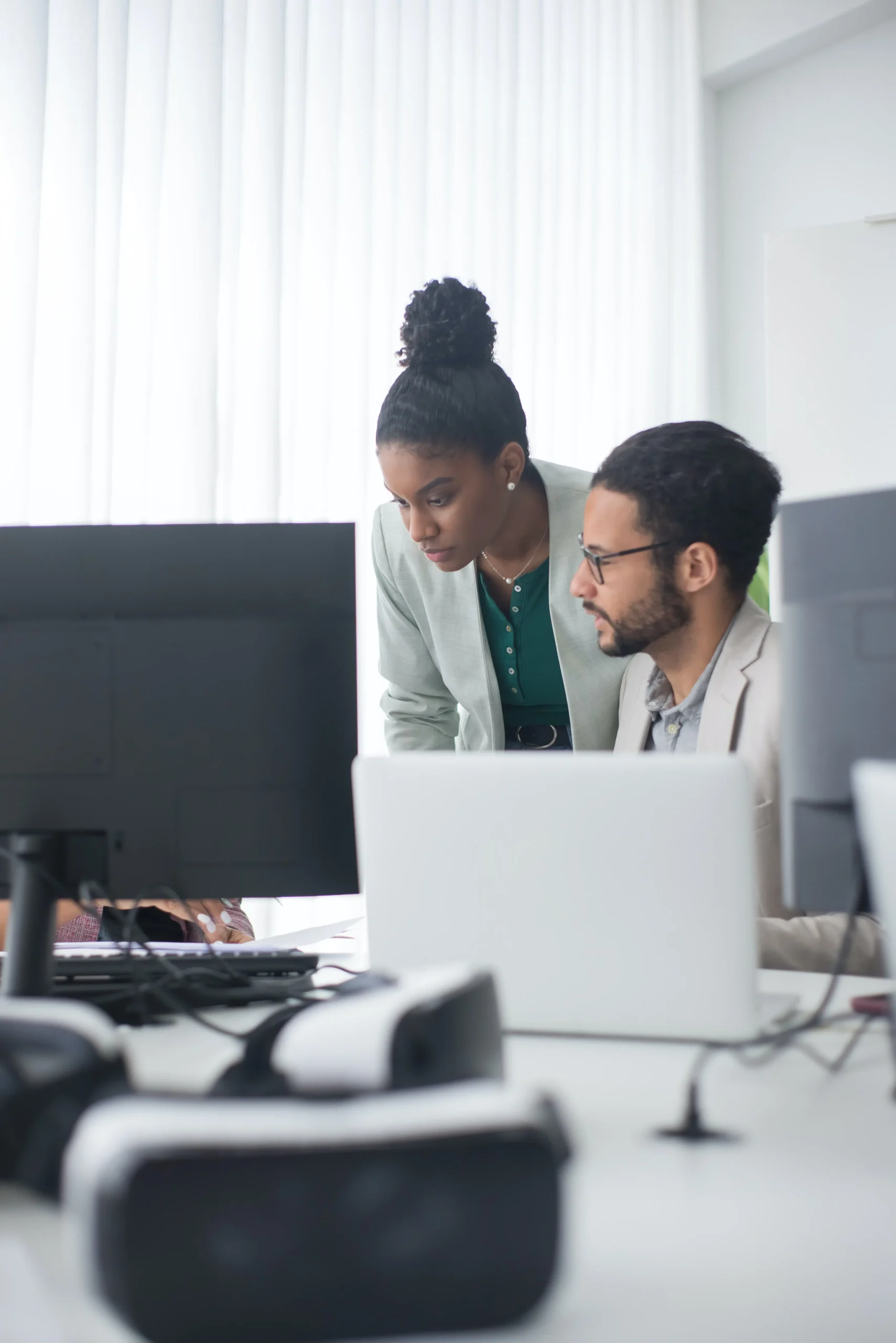 Two colleagues looking at a set of computer screens around a desk | Renewal Order Form