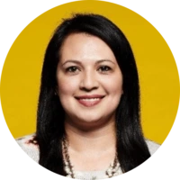 A woman with straight black hair and a light-colored top smiles at the camera against a solid yellow background, representing confidence in choosing an Icertis alternative.