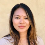 A woman with long, straight, dark hair and a light complexion smiles softly at the camera. She is wearing a light-colored top, standing in front of a plain beige background—an ideal image for highlighting a juro alternative.