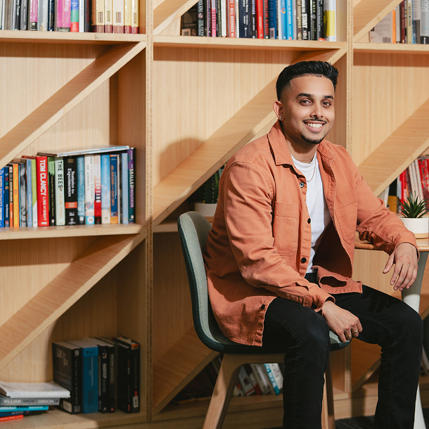 man sitting at desk in front of a book case