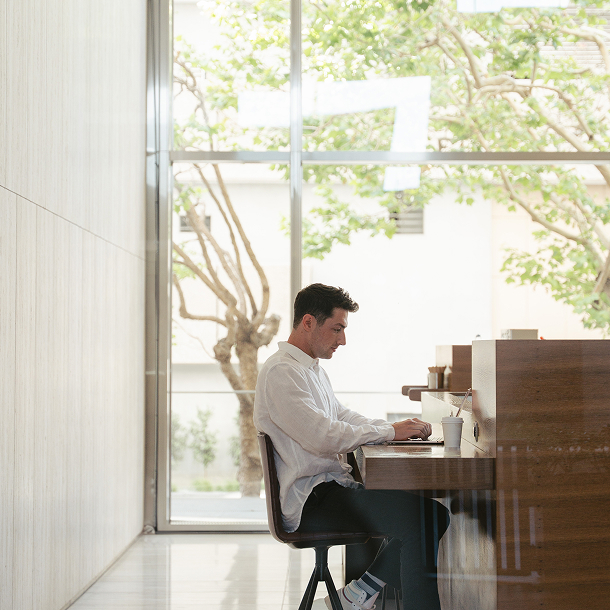 man sitting at desk in front of a window
