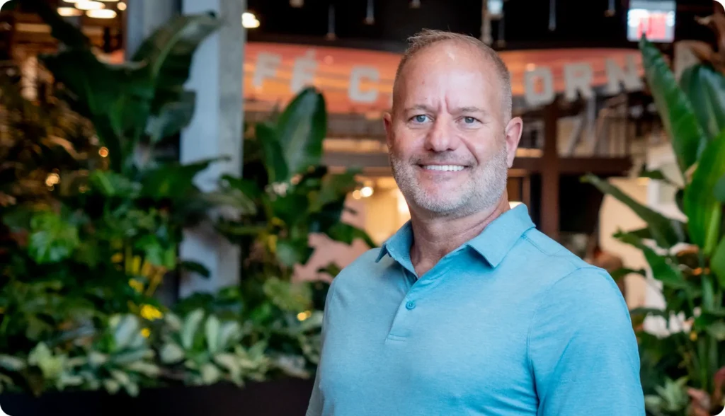 image of a man standing in front of plants smiling