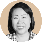 A woman with straight, dark hair, smiling and looking slightly to the side, is shown in a circular portrait with a light beige background. She is wearing a plaid shirt, embodying the approachable confidence of an Ironclad CLM professional.