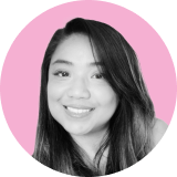 A grayscale portrait of a woman with long dark hair smiling, set against a light pink circular background, capturing the poised confidence of an ironclad clm professional.