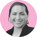 Black and white portrait of a smiling person with short dark hair, wearing a blazer and earrings, set against a pink circular background, representing the strength and confidence behind ironclad CLM.