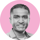 A man with short dark hair is smiling, wearing a collared shirt. The grayscale image, set against a pink circular background, features the ironclad clm logo subtly incorporated.