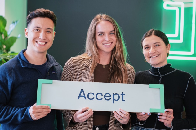 three people holding a sign that says accept