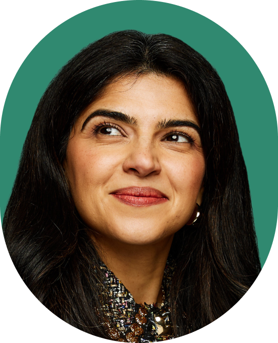 A woman with long dark hair and a patterned top smiles softly while looking off to the side. The background is a solid green color.